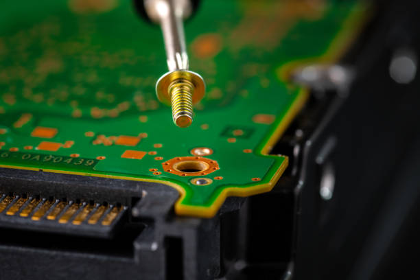 Senior computer technician (50+) performing computer maintenance. Concept: disassembly, cleaning, repair, and restoring the computer to full working condition