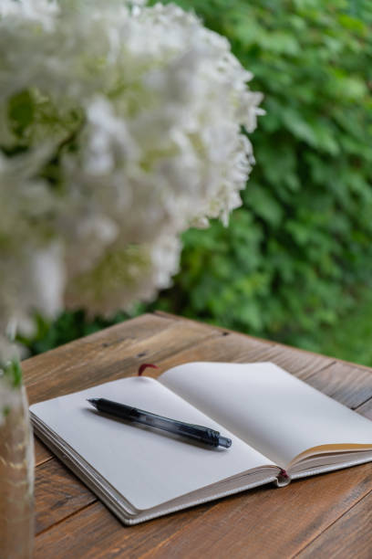istock Empty white open paper notebook in wooden table outdoors in garden. Concept of self reflection discovery journal, writing gratitude 2150903879