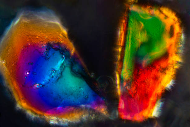 Two colorful grains of sand from San Luis Obispo, California, with polarization at 400x magnification.