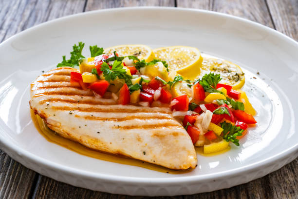 istock Grilled chicken breast and fresh vegetables on wooden table 2150909685