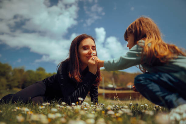Mother Smelling Beautiful Flowers from her Daughter