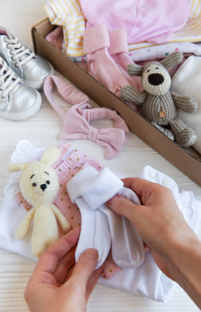 istock Women's hands collect children's clothes into boxes. 2150909959