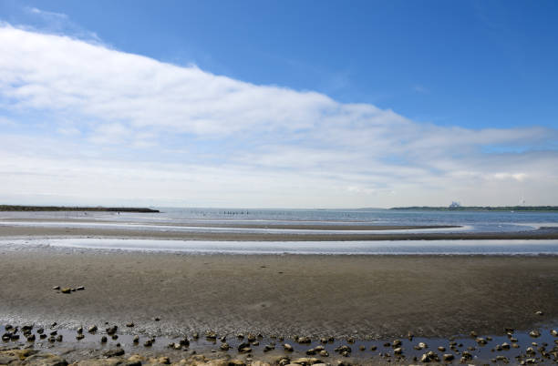 Panoramic view from the sandy Baltic sea shore on a sunny summer day. Azure water and bright cloudy blue sky. Idyllic seascape. Latvia