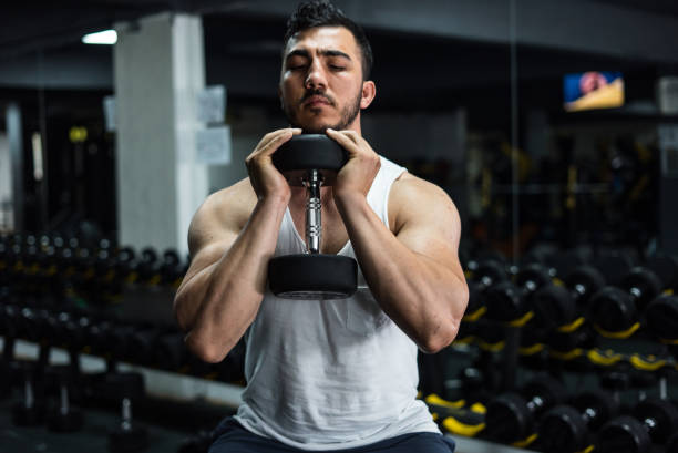 body builder is doing exercise with dumbell at gym horizontal sport still