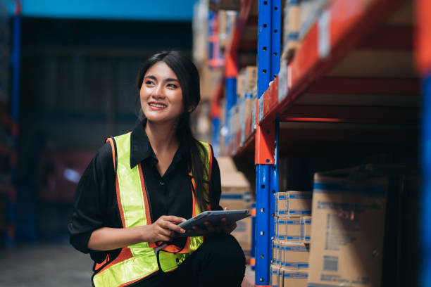 Warehouse worker working and checking the stock in the warehouse. .Factory manager using digital tablet check barcode in industry factory logistic.