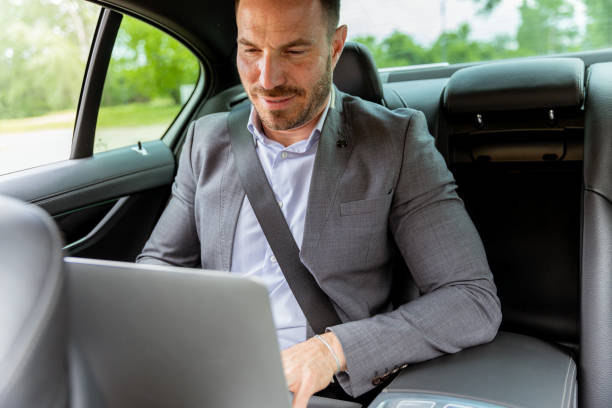 istock Business executive working on laptop in car during morning commute 2150919178