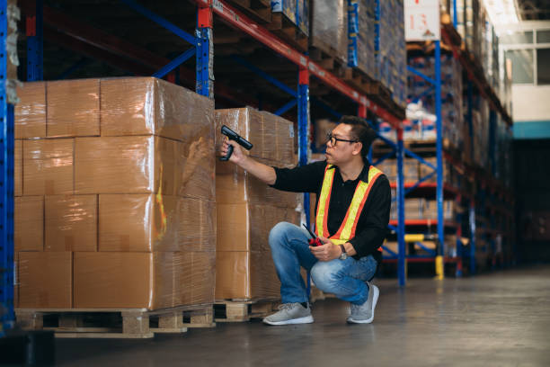 Warehouse worker working and checking the stock in the warehouse. .Factory manager using digital tablet check barcode in industry factory logistic.