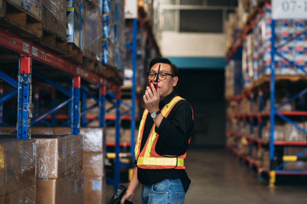 Warehouse worker working and checking the stock in the warehouse. .Factory manager using digital tablet check barcode in industry factory logistic.