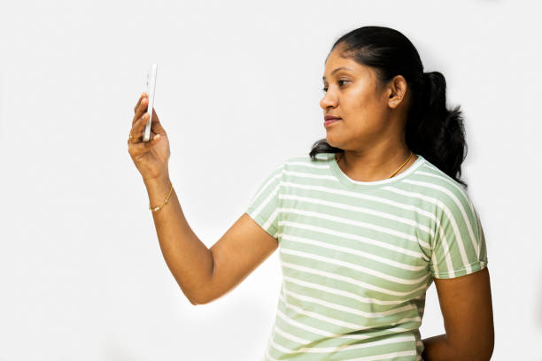 istock Woman looking at mobile phone on white background 2150919741