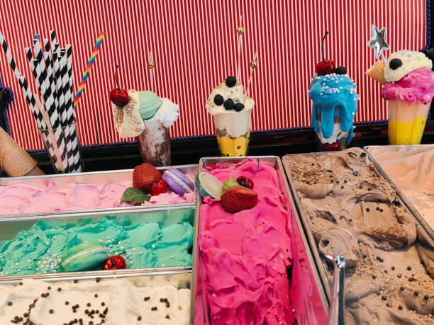 Set of ice cream scoops of different colors and flavors with berries, nuts and fruits decoration on white background