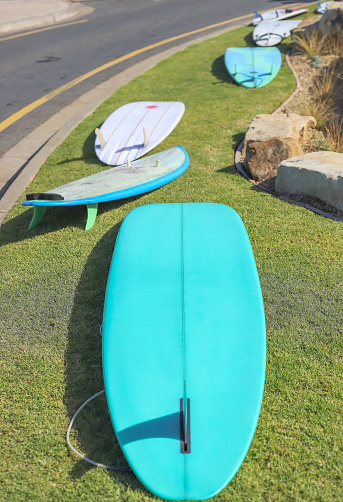 Several surfboards lie on green grass, active lifestyle. High quality photo