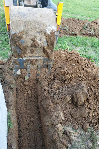 istock The excavator digs a small trench in the yard. 2150920461