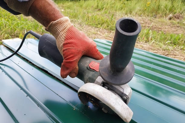 istock During the roofing work, a construction worker sprays a steel sheet with a trapezoidal profile with an angle grinder. 2150921380