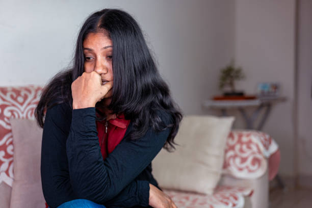 istock Sad Woman Sitting on Sofa 2150922472