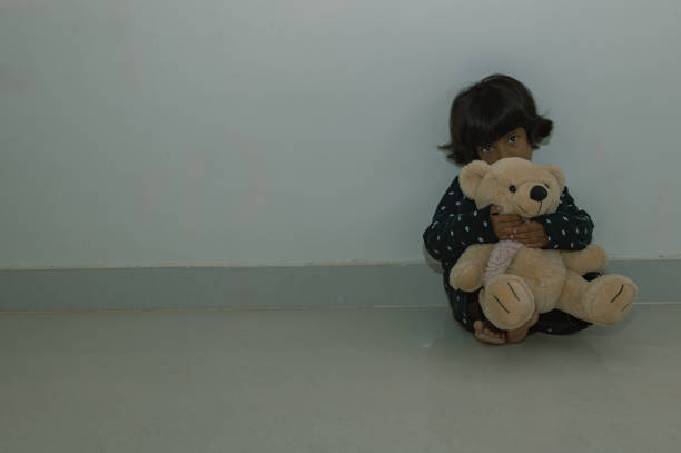 istock Sad Little Girl Sitting on the Floor 2150922532