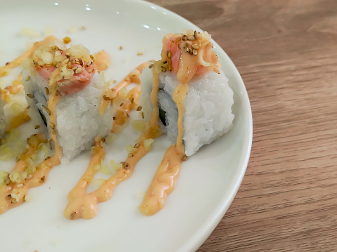 Sushi rolls with mayonnaise sauce served in white plate
