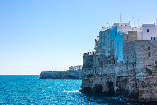 Polignano a Mare beachfront at old town. Beautiful coastal town in Apulia is being attracted to many tourists which are seen on platforms in the city.