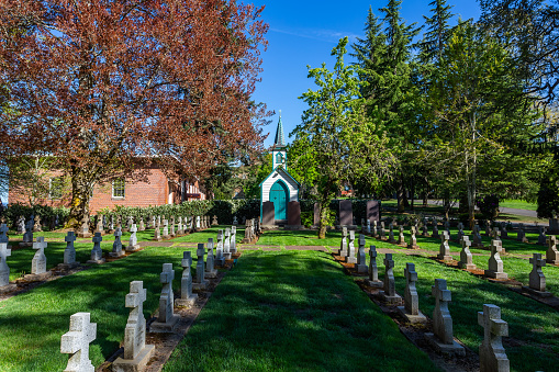 Mount Angel, Oregon, USA - April 19th, 2024: Chapel and grave crosses in the Abbey cemetery