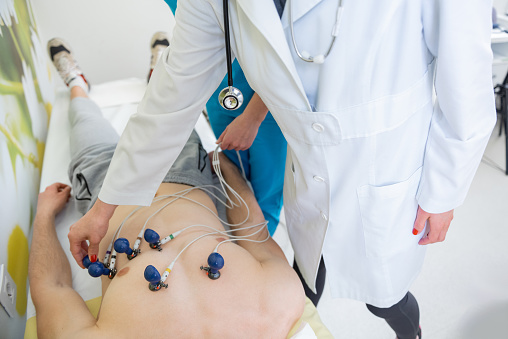 Skilled practitioner carefully attaches EKG electrodes to a patient for heart monitoring