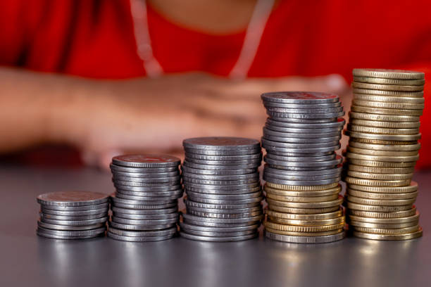 istock Stack of Coins with Blurred Kids in Background 2150925123