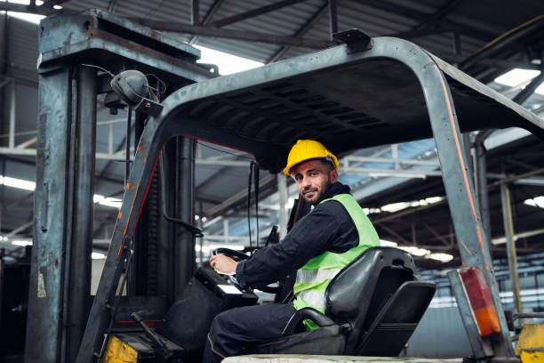istock A man in a yellow helmet is driving a forklift in a warehouse 2150925797