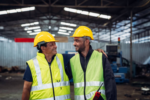istock Two men wearing safety gear and smiling at the camera 2150925956