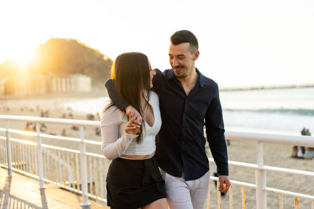 istock Romantic couple embracing walking along a promenade during sunset 2150927714