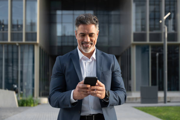 istock Successful mature hispanic senior business man using smartphone cellphone financial application. Indian or latin confident middle age male entrepreneur businessman holding mobile cell phone for invest 2150927746