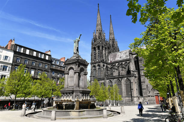 Clermont-Ferrand, France-04 12 2024: People on Place de la Victoire with the Notre-Dame-de-l'Assomption cathedral built of lava stones in the background, Clermont-Ferrand, France.