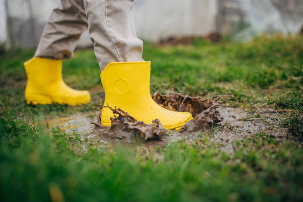 istock Person stepping in mud with yellow boots 2150929678