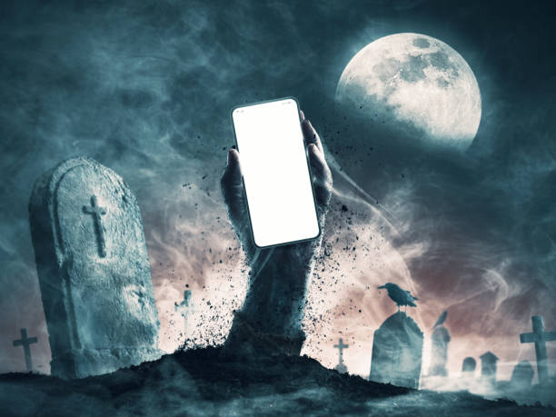 istock Zombie holding a smartphone in the graveyard 2150931729