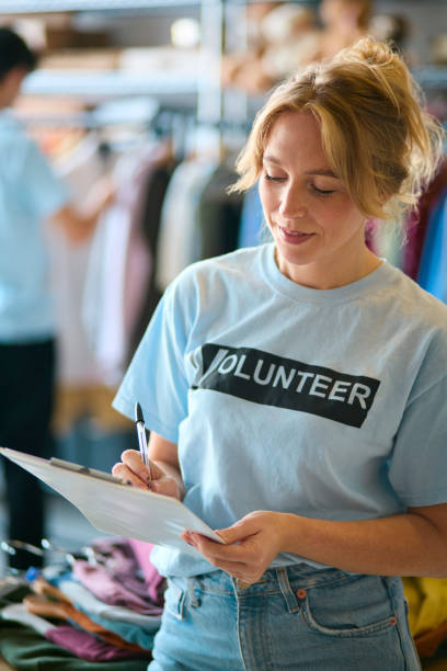 istock Female Charity Worker Checking Clothing Donations At Thrift Store 2150933498
