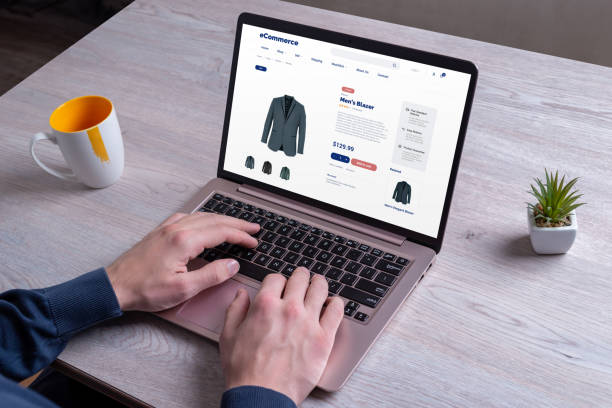 istock Shopping for men's blazers online, exploring various colors, using a laptop on an e-commerce platform for a seamless experience 2150933860