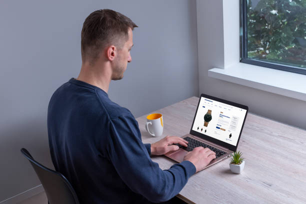 istock Man browsing online for watches on specialized website using laptop, seeking style and quality, from home work desk 2150934241