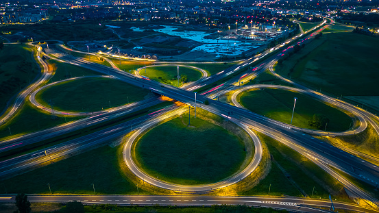 Road and Roundabout, multilevel junction motorway at night. Expressway top view. A51 Tangenziale Est di Milano, Italy. High quality photo