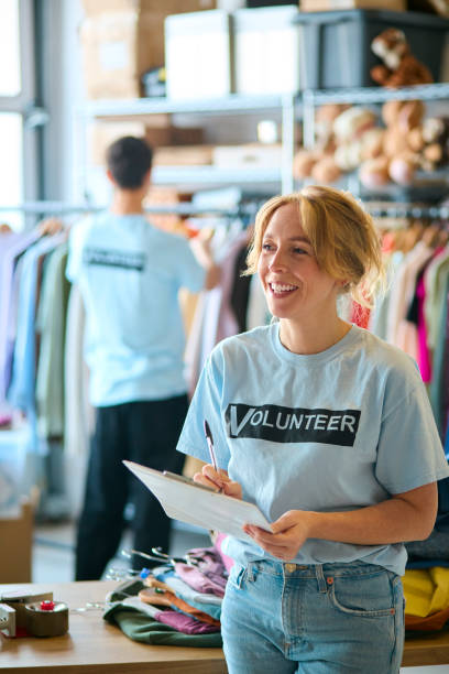 istock Female Charity Worker Checking Clothing Donations At Thrift Store 2150940783