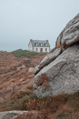 Small building among the rocks above the Atlantic Ocean. The lighthouse phare du Millier at the Pointe du Millier, Cap Sizun at Beuzec-Cap-Sizun, Finistère, Brittany, France