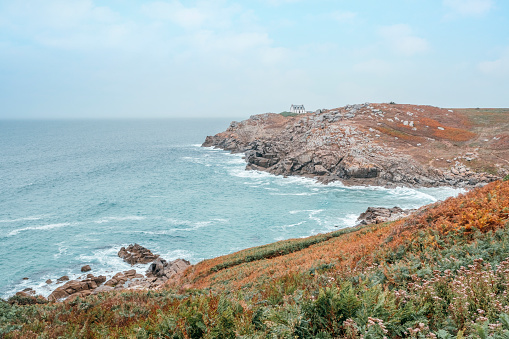 View of the coast with a small building among the rocks above the Atlantic Ocean. The lighthouse phare du Millier at the Pointe du Millier, Cap Sizun at Beuzec-Cap-Sizun, Finistère