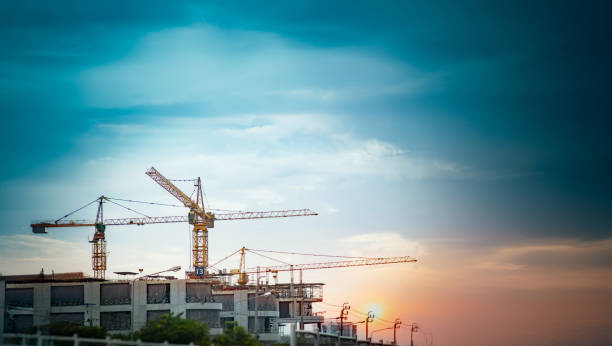 about 3 tower cranes installed at a construction site to build the city and blue sky