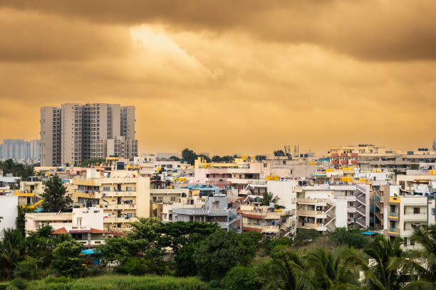 This long shot photo captures a beautiful Indian cityscape with a vibrant orange sky. The city is filled with a variety of traditional Indian buildings,