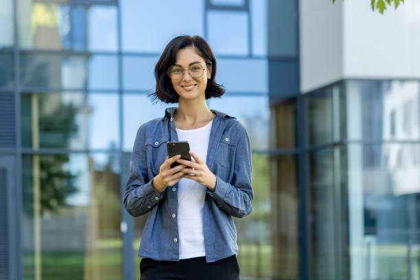 istock Smiling businesswoman using smartphone in urban setting 2150951999