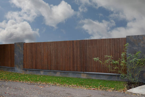 istock Brown wooden fence with linear planks on a sky background 2150952406