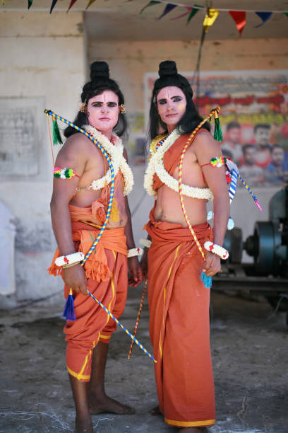 Local people dressed as Hindu Gods, Ram and Laxman, for a traditional festival in a village at Poondi, Tamil Nadu. The vibrant costumes and detailed makeup highlight the rich cultural heritage and religious traditions of the region. The festive atmosphere and colorful attire reflect the community's deep devotion and celebration of their cultural roots.