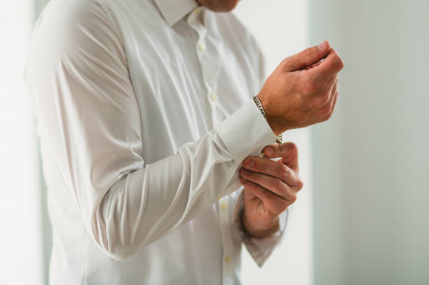 Groom buttoning his shirt