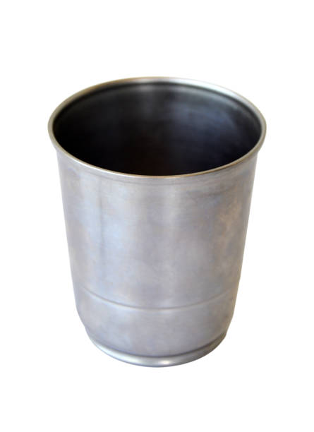 Vertical image of cut out of one empty solid durable reusable sturdy safe metal shiny stainless steel drinking glass, cup, mug or cup, container without lid front view over blank white transparent background