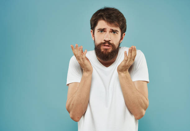 istock Young man with a beard on a blue background emotions model frightened look 2150955701