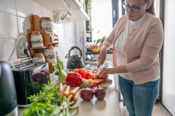 istock Woman chopping vegetables at home 2150956471