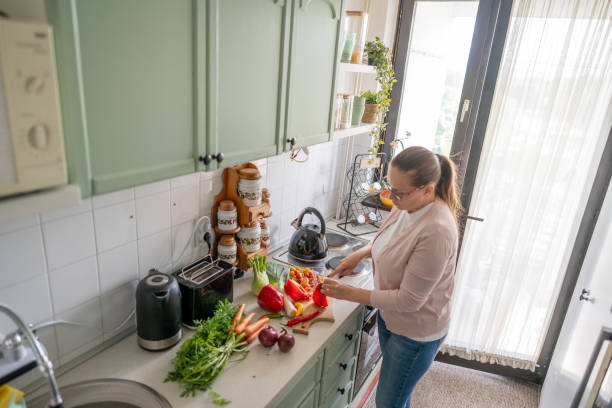 istock Woman chopping vegetables at home 2150956866