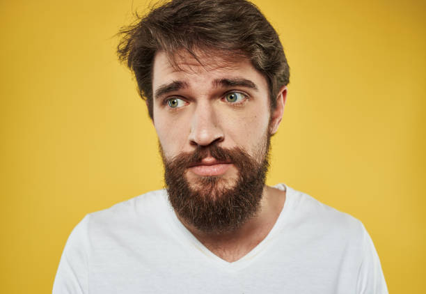 istock man on a yellow background in a white t-shirt sad face beard model 2150956917