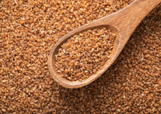 istock Spoon with raw organic healthy brown bulgur seeds.Macro. 2150957076